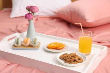 Nefis bir kahvaltı tepsisi ve çiçeklerle kapalı bir yerde, yakın plan.