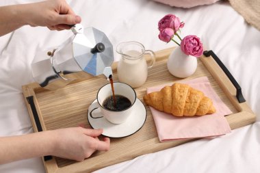 Kadın yatakta nefis bir kahvaltı yapıyor, yakın plan.