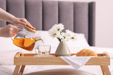 Kadın yatakta nefis bir kahvaltı yapıyor, yakın plan.