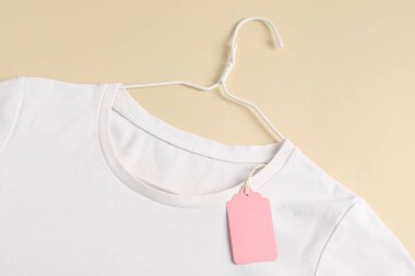 Bej arkaplan etiketli beyaz tişört, üst görünüm