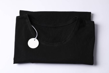 Beyaz arkaplanda etiketli tişört, üst görünüm