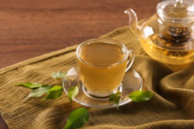 Bir fincan lezzetli yeşil çay ve çaydanlık masanın üstünde, yakın plan.