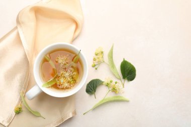 Taze ıhlamur çayı fincanda, çiçekler beyaz masada, düz yerde. Metin için boşluk