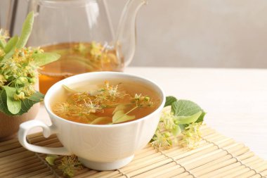 Taze ıhlamur çayı, çaydanlık ve çiçekler beyaz masada, yakın plan. Metin için boşluk