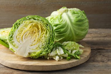 Ahşap masada kesim ve tüm lahanalar, yakın plan.