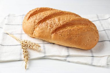 Taze ekmek somunu ve çiviler beyaz ahşap masada, yakın plan.