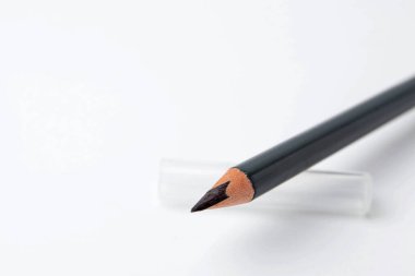 Beyaz arka planda siyah kaş kalemi, yakın plan. Metin için boşluk