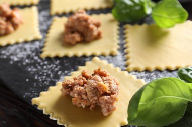 Ahşap masada ravioli bolonez yapıyorum, yakın plan.