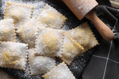 Pişmemiş ravioli ve merdane masanın üstünde.