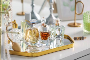 Beyaz masadaki farklı parfümlerden şişeler, yakın plan.