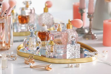 İçerideki tuvalet masasında farklı parfüm ve aksesuar şişeleri, yakın plan.