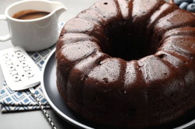 Lezzetli çikolatalı kek ve garson gri masada, yakın plan.