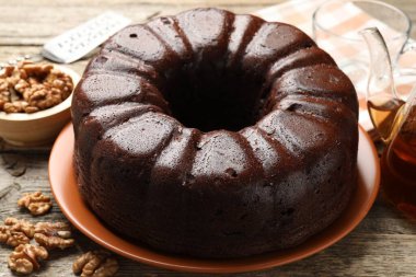 Lezzetli çikolatalı kek, ceviz ve çay ahşap masada, yakın plan.