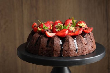 Çilekli, naneli ve çikolatalı kek bulanık arka planda duruyor, yakın planda.