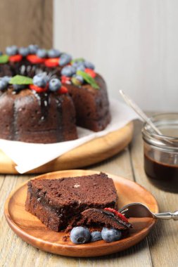 Ahşap masada yaban mersinli lezzetli çikolatalı kek, yakın plan.