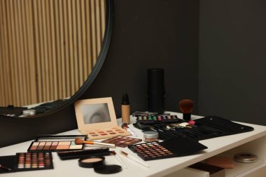 Tuvalet masasında farklı makyaj malzemeleri var.