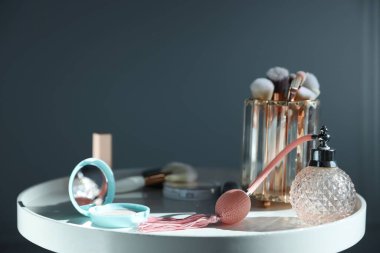 Beyaz masadaki farklı makyaj ürünleri gri arka planda, yakın planda