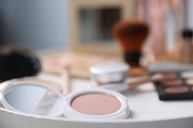 Beyaz masada farklı makyaj ürünleri, kapalı masa, yakın çekim.