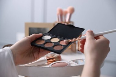 Kapalı bir masada fırça ve göz falı bir kadın, yakın plan.