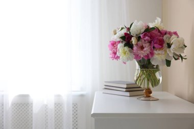 Bir buket güzel şakayık ve beyaz masa üzerinde kitaplar, yazı için yer. İç tasarım