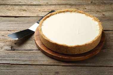 Bir lezzetli cheesecake ve sunucu ahşap masada, yakın plan.
