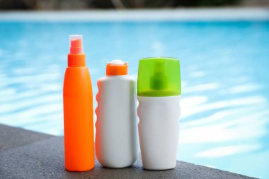 Güneş koruma ürünleri yüzme havuzunun yakınındaki taş yüzeyde.