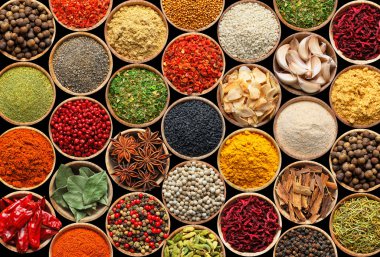 Siyah arka plandaki kaselerde farklı aromatik baharatlar dizisi.