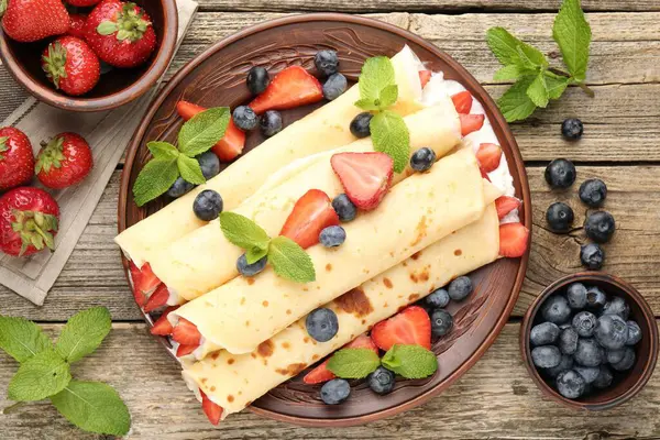 Böğürtlenli krep, krema ve nane, ahşap masa, düz uzanma