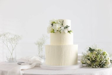 Çiçekli düğün pastası ve kapalı masa desenli lezzetli bir pasta.