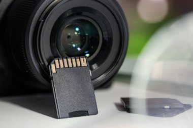 SD hafıza kartları ve fotoğraf makinesi beyaz masada, yakın plan.