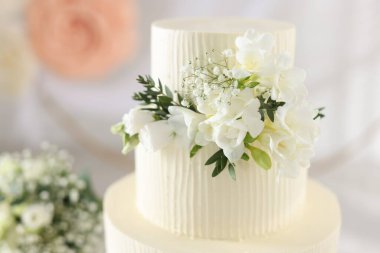 Çiçek desenli nefis bir düğün pastası ve kapalı bir masa, yakın plan.