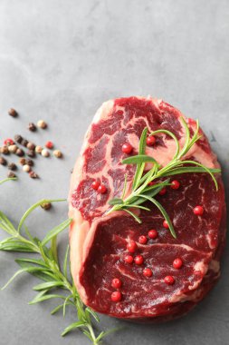 Gri desenli masada çiğ et ve baharat var.