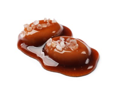 Lezzetli tatlı şekerler, beyaz üzerine izole edilmiş tuz ve karamel sosu.