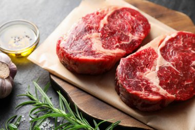 Çiğ et parçaları ve baharatlar siyah masada, yakın plan.