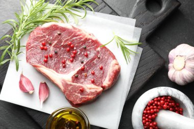 Siyah masada çiğ et ve baharat var.