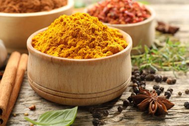 Ahşap masada farklı aromatik baharatlar, yakın plan.