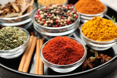 Açık gri masada farklı aromatik baharatlar, yakın plan.