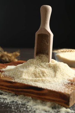 Siyah arkaplana karşı koyu masa üzerine un ve kepçe yığını, yakın plan