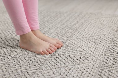 Evdeki gri halıdaki kız, yakın plan. Metin için boşluk