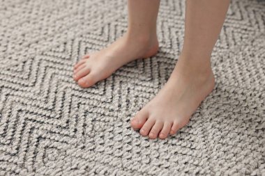 Evdeki gri halıdaki kız, yakın plan.