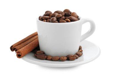 Kavrulmuş kahve çekirdekleri ve beyaz üzerine izole edilmiş tarçın ile seramik fincan.