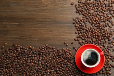 Aromatik kahve fincanda, fasulye de tahta masada, düz yerde. Metin için boşluk