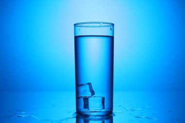 Ayna masasında buzlu taze su mavi gradyan arka planda, yakın plan.