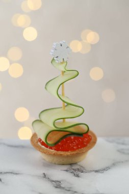 Arka planı bulanık ışıklarla kaplı, beyaz mermer masa üzerinde güzel bir kanepe, yakın plan. Bokeh etkisi