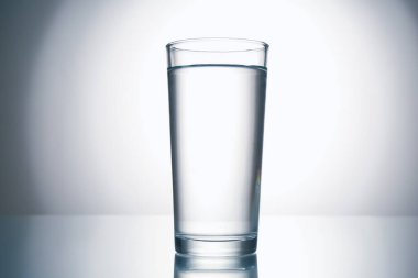 Gri gradyan arkaplana karşı ayna masasında taze su