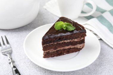 Gri masadaki çatal ve naneli çikolatalı kek, yakın plan.