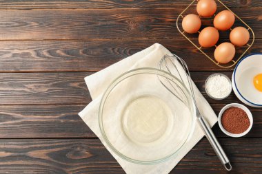 Krem şanti yapıyorum. Tabak, çırpma ve malzemeler ahşap masada, düz yerde. Metin için boşluk
