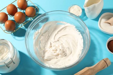 Krem şanti kasede ve diğer ürünler açık mavi masada, yukarıda.