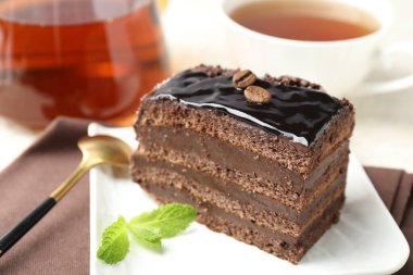 Nane, kaşık ve çayla servis edilen çikolatalı kek.