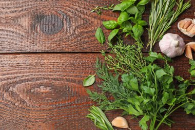 Farklı taze otlar ve baharatlar ahşap masada, düz yerde. Metin için boşluk